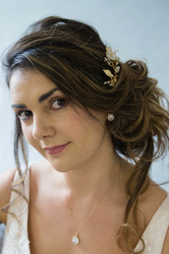 Bride with a messy updo hairstyle wearing Kayla Gold Hairpins - gold Leaf and mother of pearl flower wedding hairpins.
