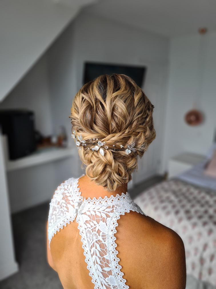 Bride ready for her wedding, back of lace dress with textured hairstyle and bridal hairvine