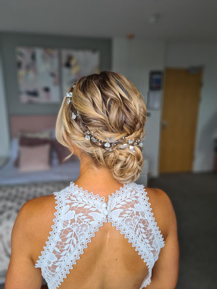 Pretty hair up style on a bride with flower and leaf hairvine