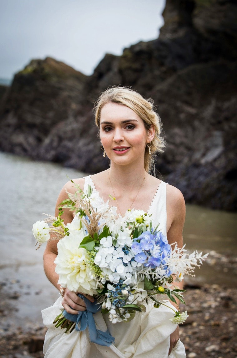 bride on the beach boho style wedding with blue dried bouquet and silk dress