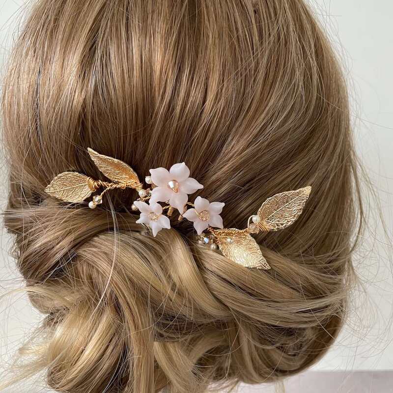 bridal updo hairstyle with a blush pin floral hairpin with gold leaves
