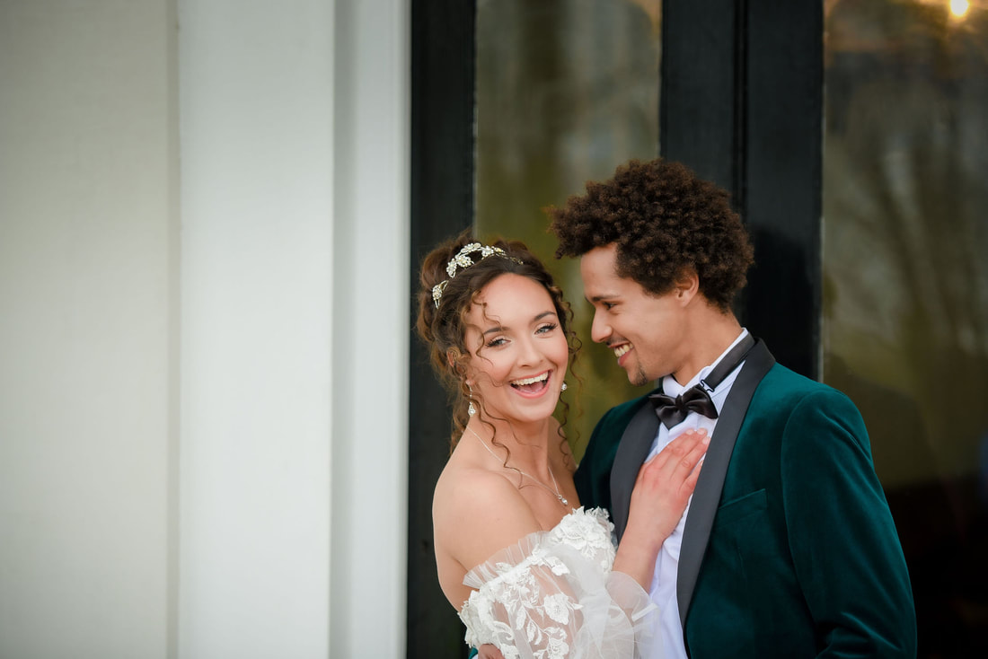 bride and groom smiling dark green groom jacket and soft lace floral wedding dress at a country house