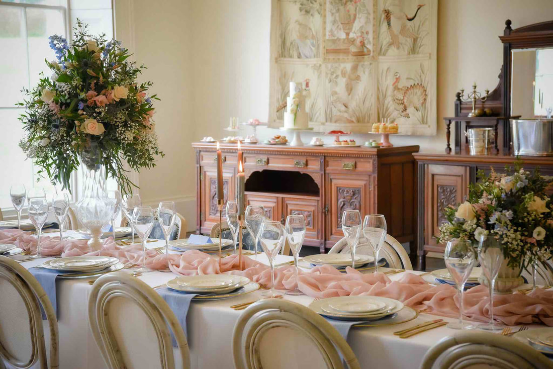 Wedding banquet table set up with blush pink fabric and pale blue, elegant floral arrangements country house bideford